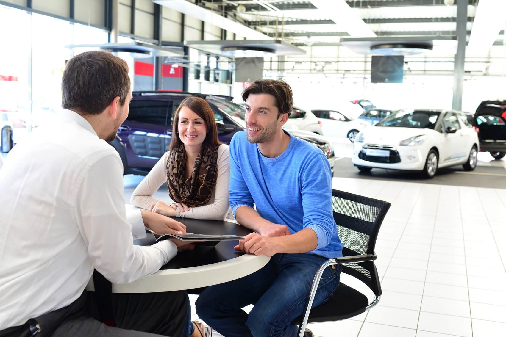 smiling customers talk to chevy finance rep about chevy lease options